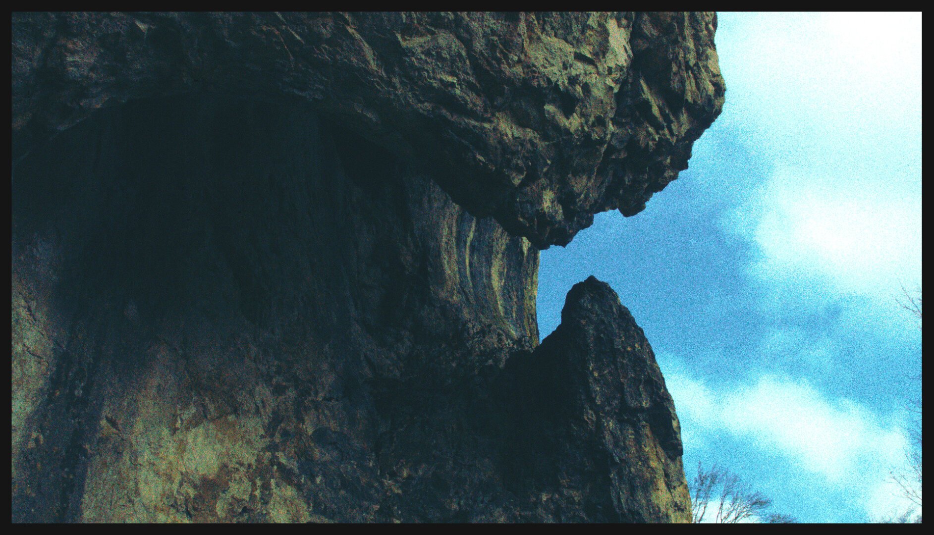 Picture of a huge rock photographed from below. It looks like it's pinching something