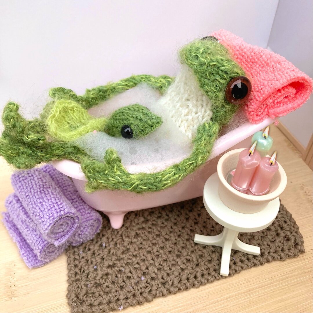 Cute knitted frog and tadpole in a miniature bubble bath