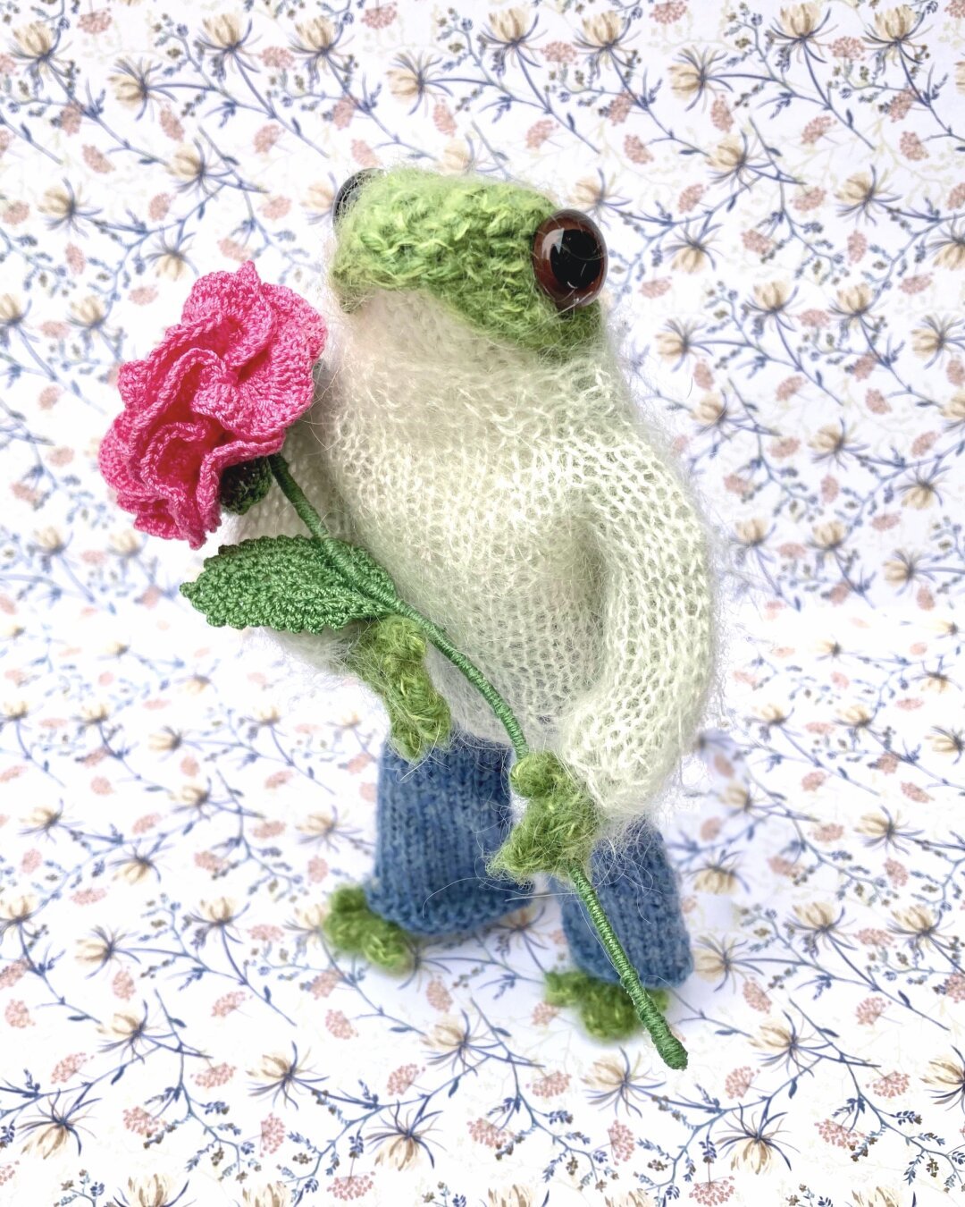 Knitted frog with crochet rose.