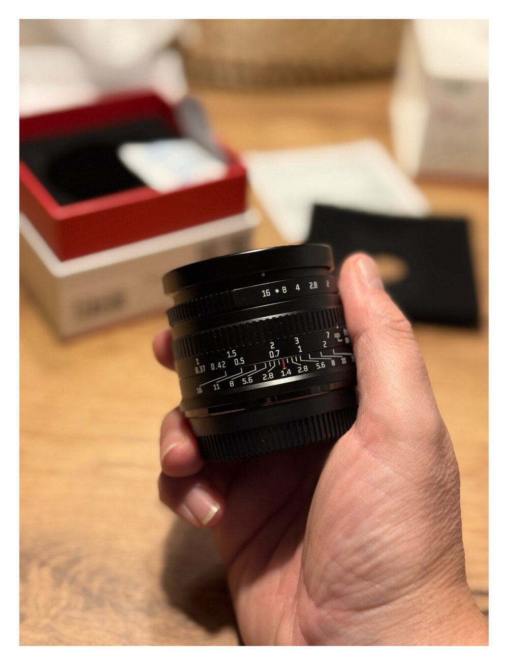 Ich halte ein relativ kleines schwarzes 35mm Objektiv in der Hand. Darauf sind viele Zahlen. Ich halte ein relativ kleines schwarzes 35mm Objektiv in der Hand. Darauf sind viele Zahlen.