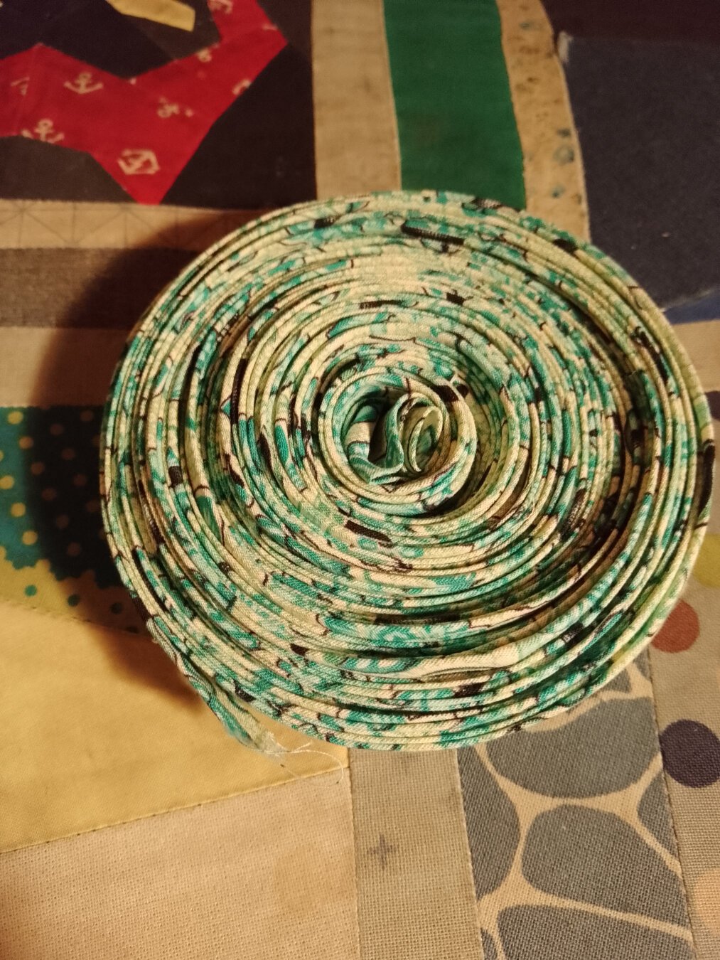 A coil of bias binding. The fabric is a wild, green pattern.