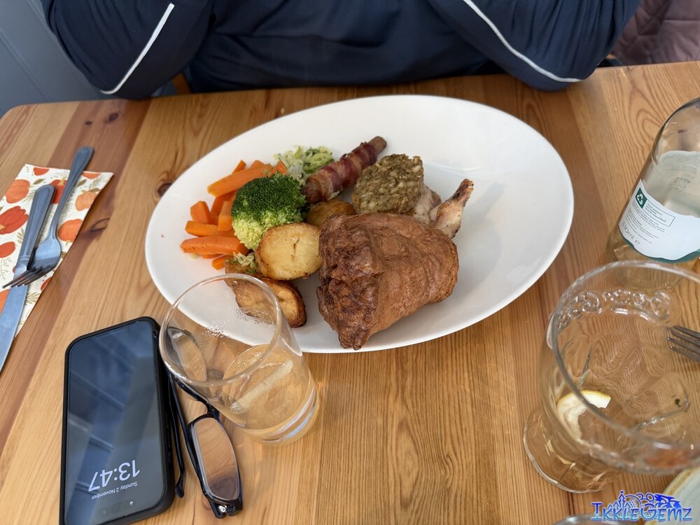 Chicken roast with roast potatoes, carrots, broccoli, stuffing, a pig in a blanket and cabbage