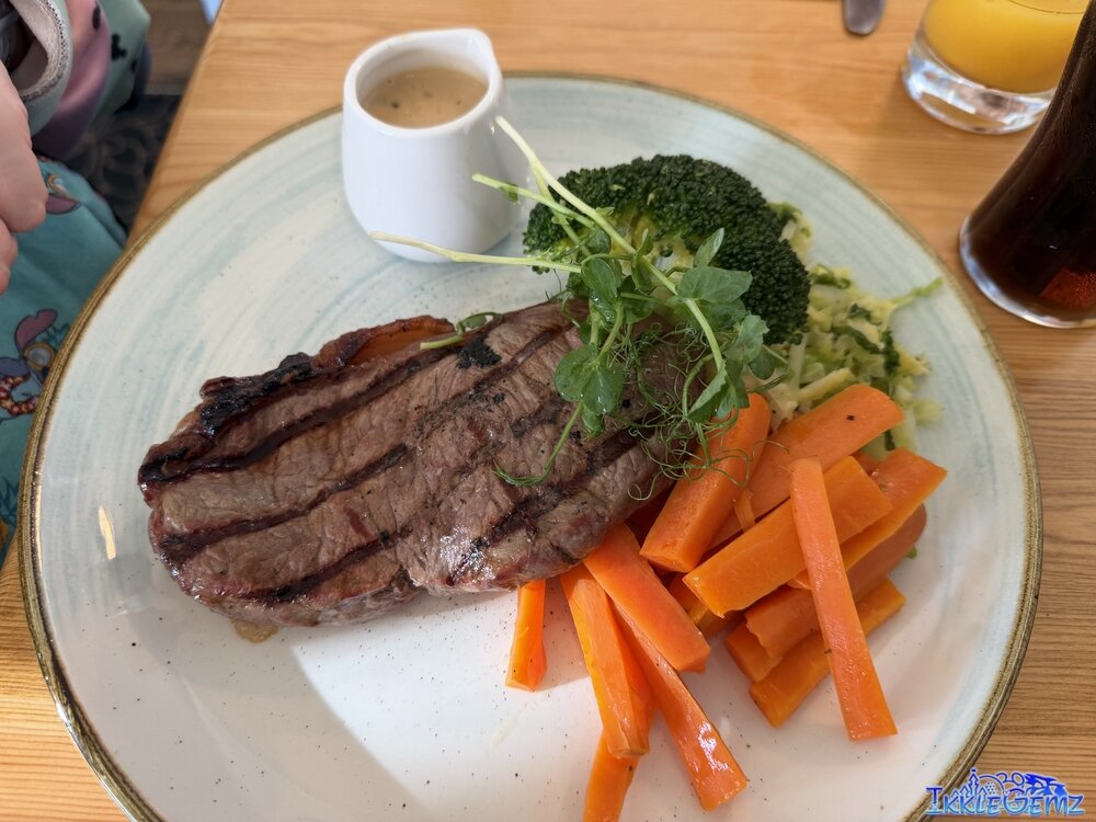 Steak with peppercorn sauce, potatoes, carrots, broccoli and cabbage