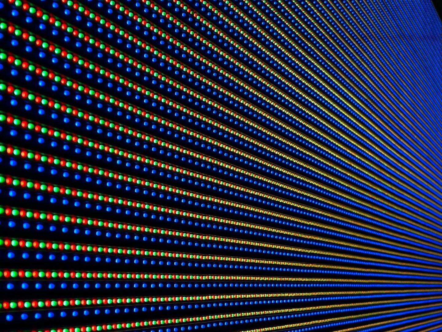 Geometric-looking rows of LEDs lit red, green and blue. All together they make up a white notice board, but this pic is up close so you can see the detail of every LED. The dominant color is blue, with the green and red less noticeable.