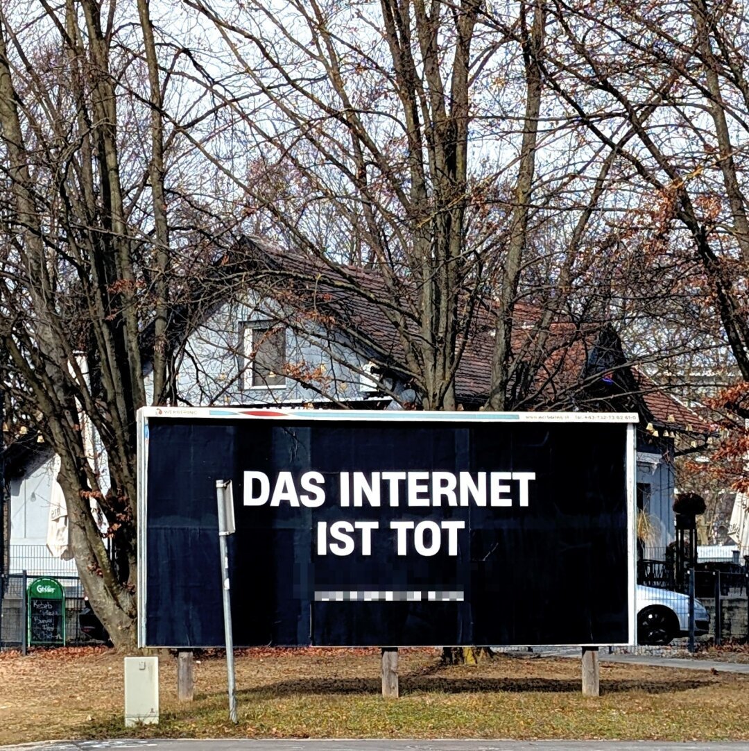 Straßenplakat: Große weiße Großbuchstaben auf komplett schwarzem Grund. Kleiner Link darunter von mir ausgepixelt.Text:
Das Internet ist tot