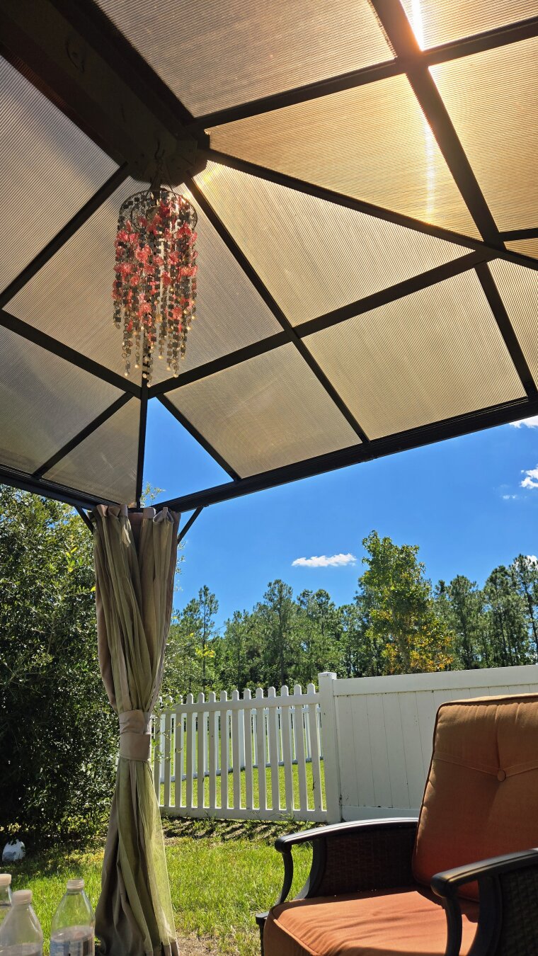 Under an outdoor patio in the sunshine. The sun is shining through the gold roof.