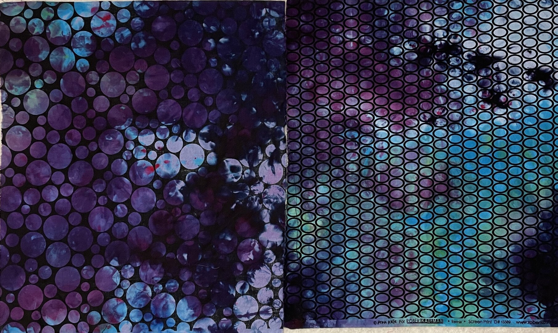 2 fat quarters of black and white prints that have been ice dyed with mostly purple and some greens and blues.