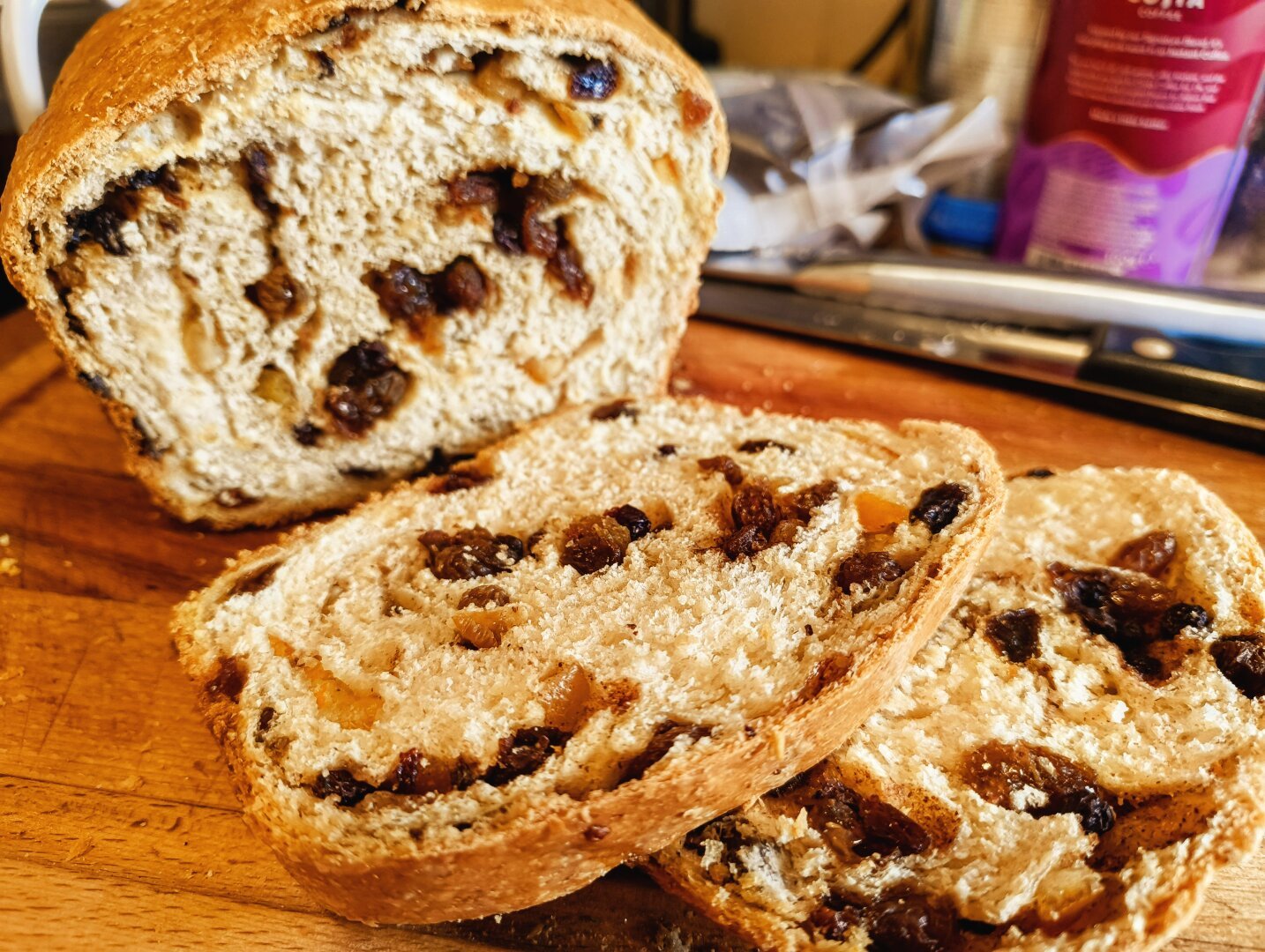 A sliced fruit loaf, showing plump raisins and sultanas inside.