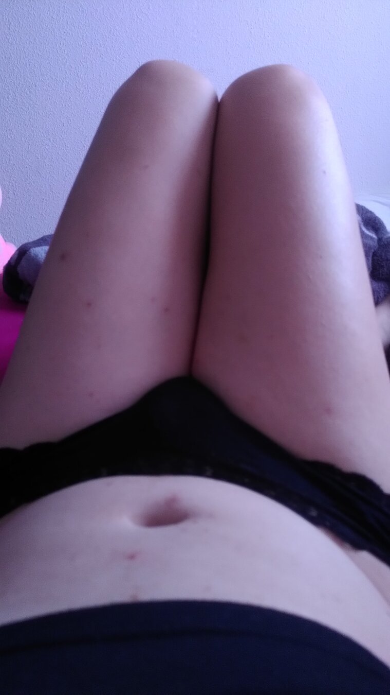 Photo of my legs and belly from my point of view. I'm white and wearing black panties And a black crop top.