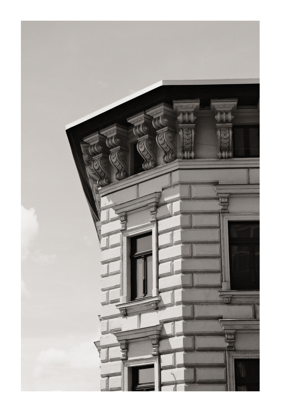 Schwarz-weiß-Foto einer historischen Gebäudeecke mit verzierten Fassadenelementen im Stil der Renaissance oder des Barock.