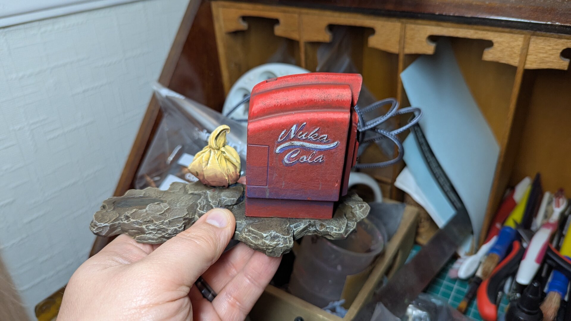 Right side of a 3d printed nuka cola base for a 90mm scale figure painted and weathered to look like a vending machine from the popular TV series