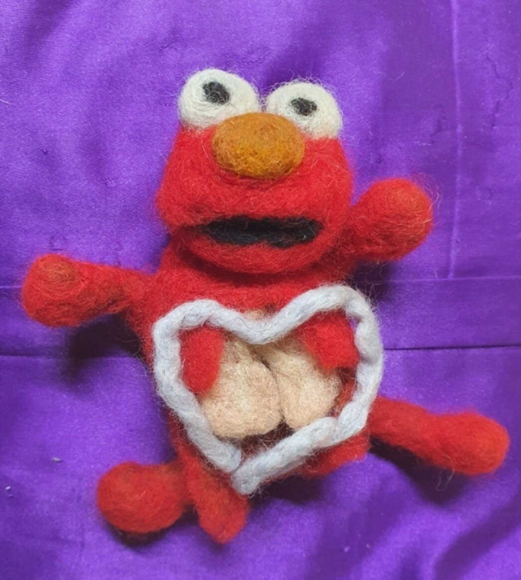 A felt model of elmo, eviscerated, with his intestines forming a heart shape