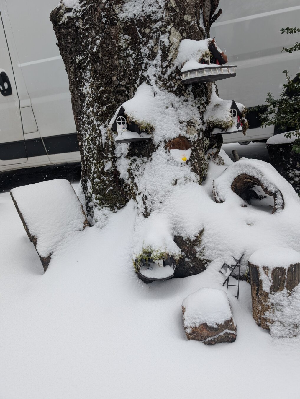 Snow covered gnome house in a stump