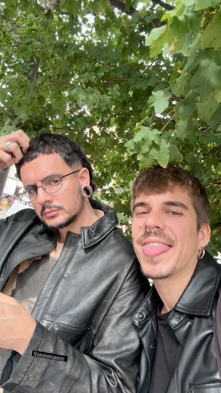 Yo y mi novio con chaquetas de cuero sobre un fondo de hojas verdes