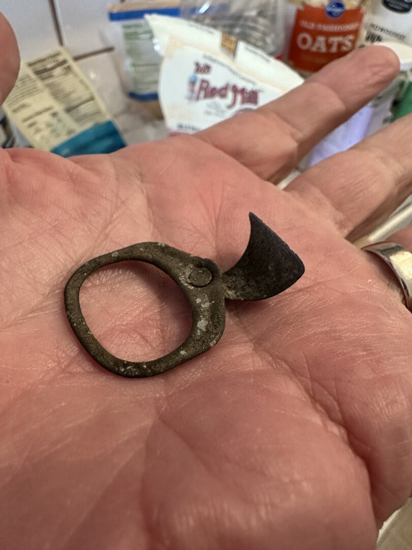 A rusty pull tab resting in the palm of my hand.