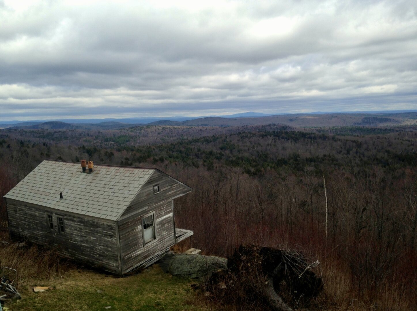 A small, weathered house sits precariously on the edge of a steep drop off on Hogback Mountain.