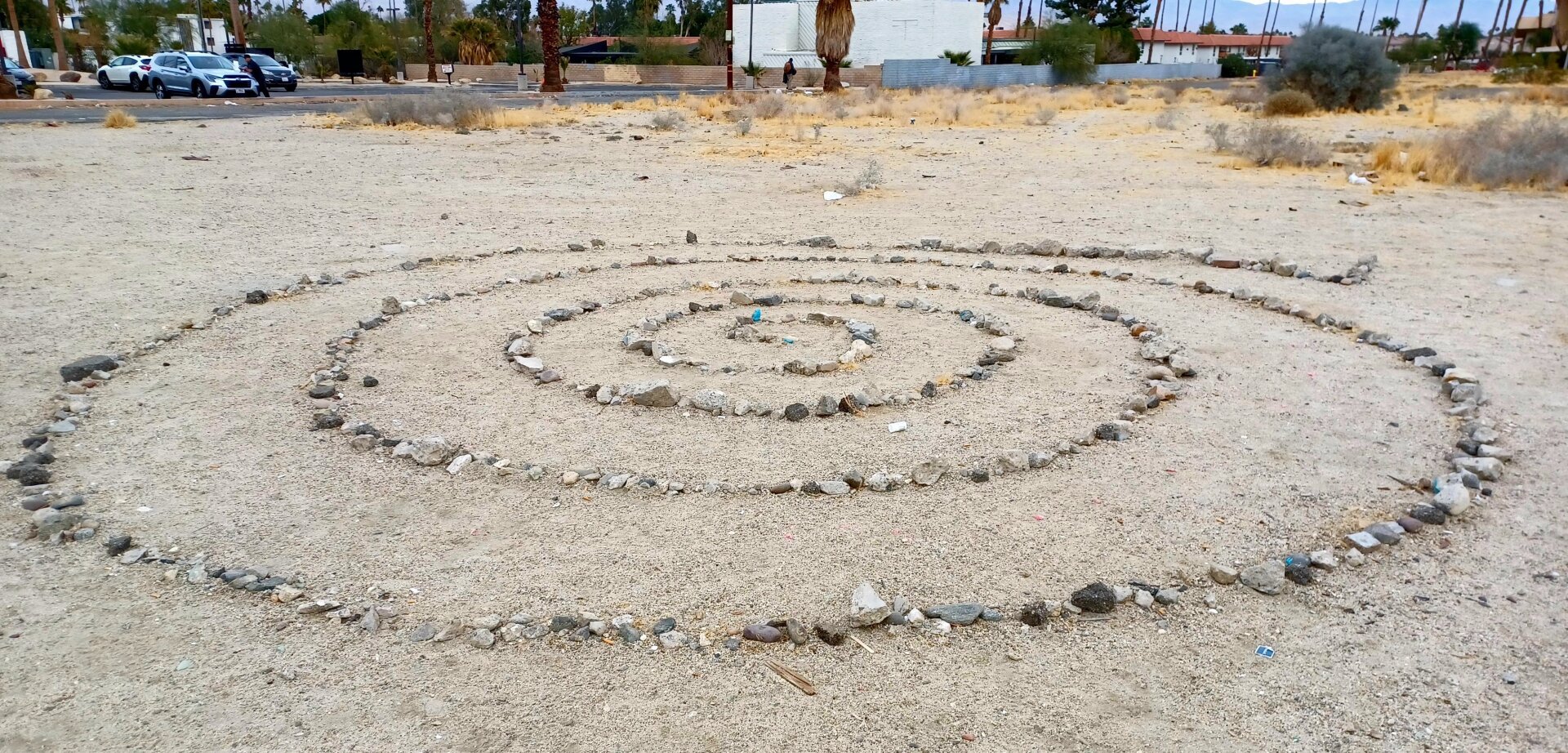 Spiral in the sand made of crushed rubble.