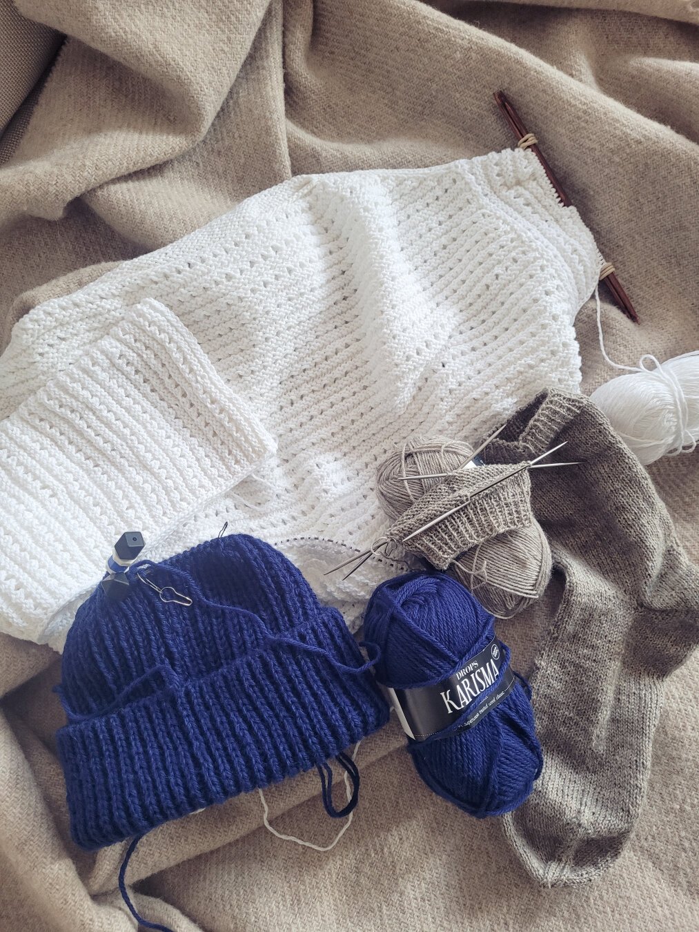 ENG 3 unfinished knitting projects: a white Blouse No. 2, a blue Ole Hat and a greige pair of plan socks.

DEU 3 halbfertige Strickprojekte: eine weiße Blouse No. 2, eine blaue Ole Mütze und ein Paar Socken in Greige