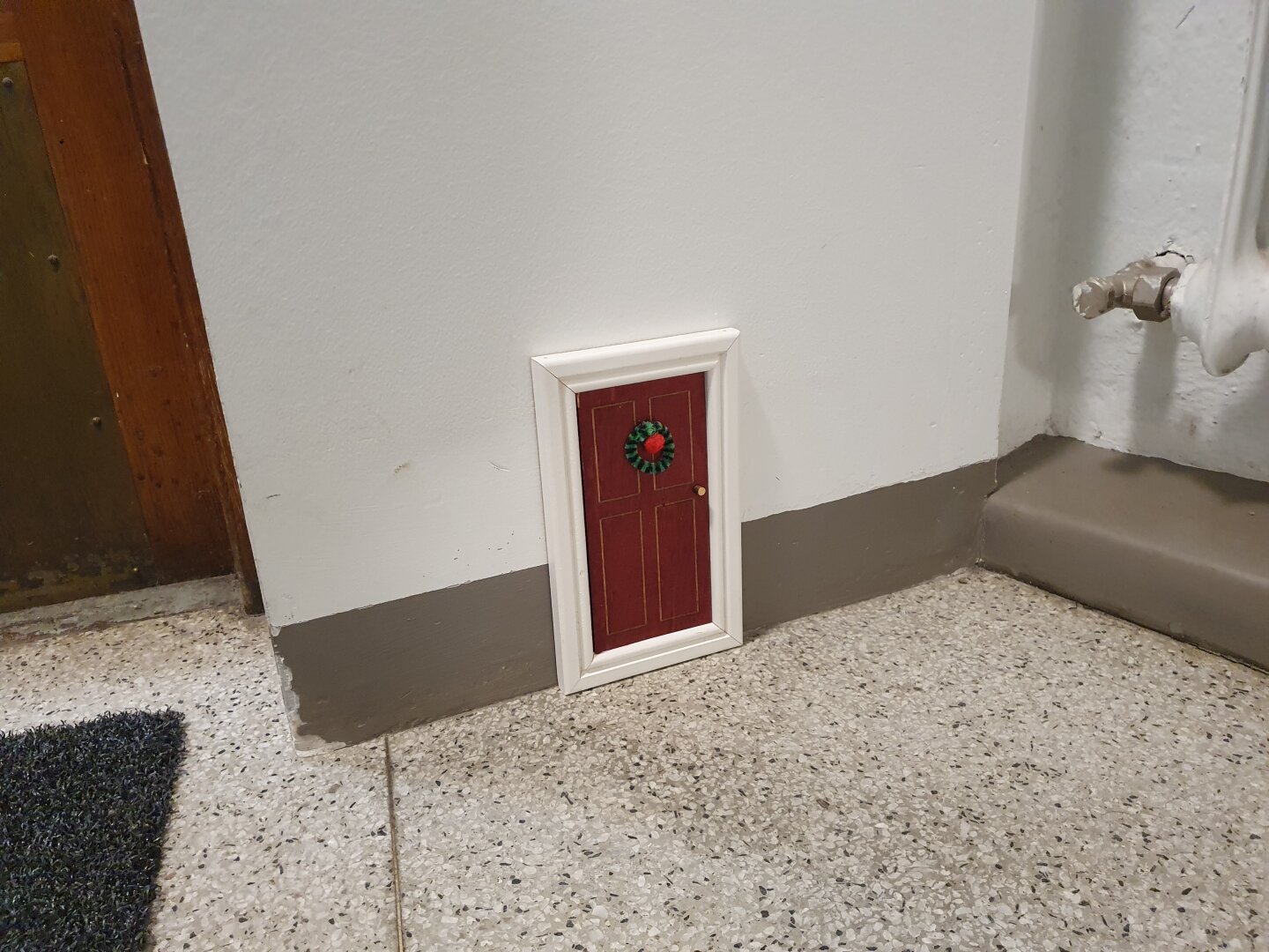 Nissedörren i trappuppgången har en lite julkrans.