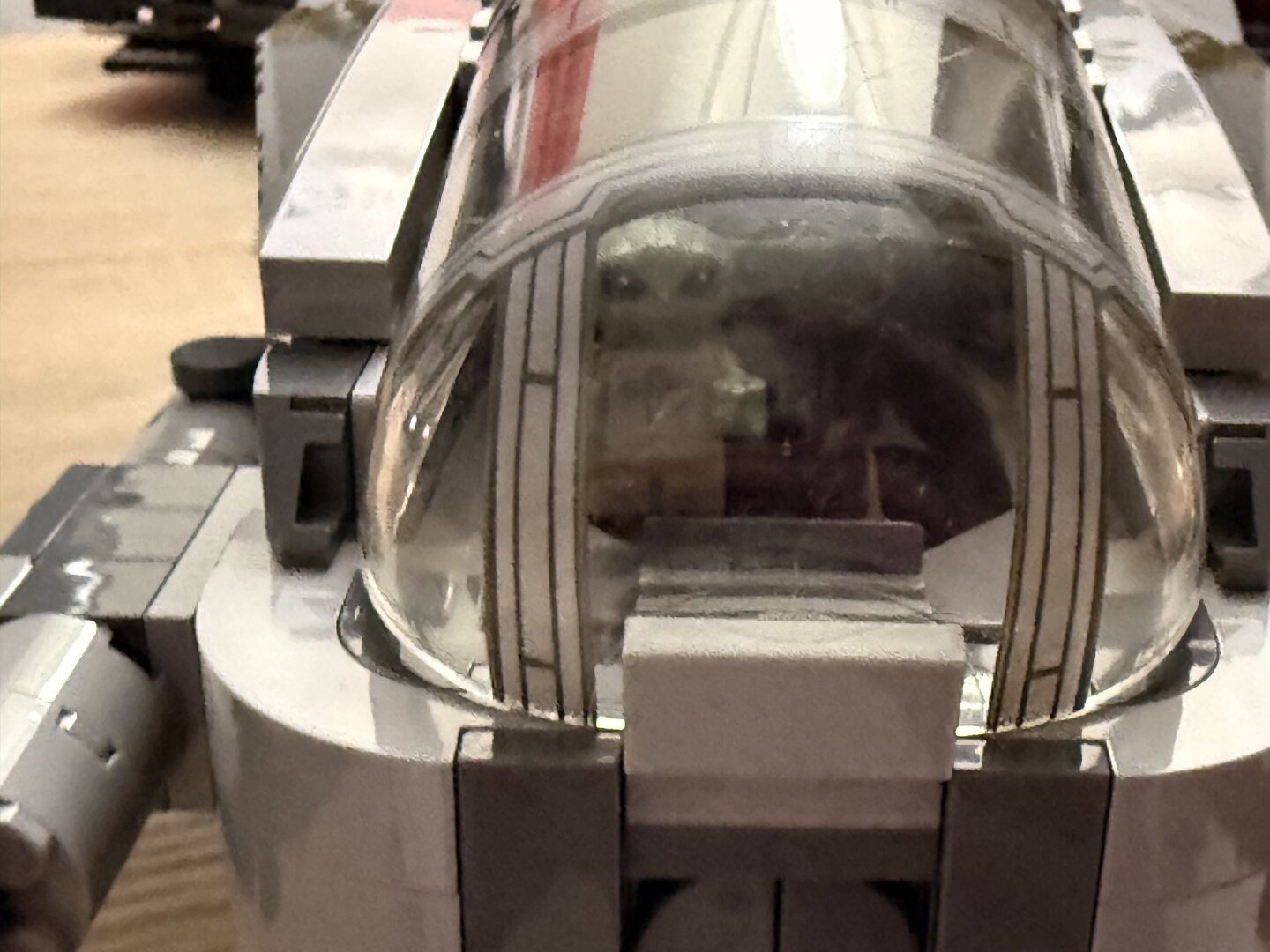 Grogu aka The Child viewed through the cabin canopy of the completed razor crest