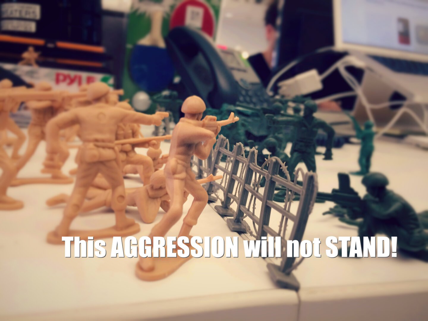 Toy soldiers are posed in a battle scene on a table, with text saying This AGGRESSION will not STAND!