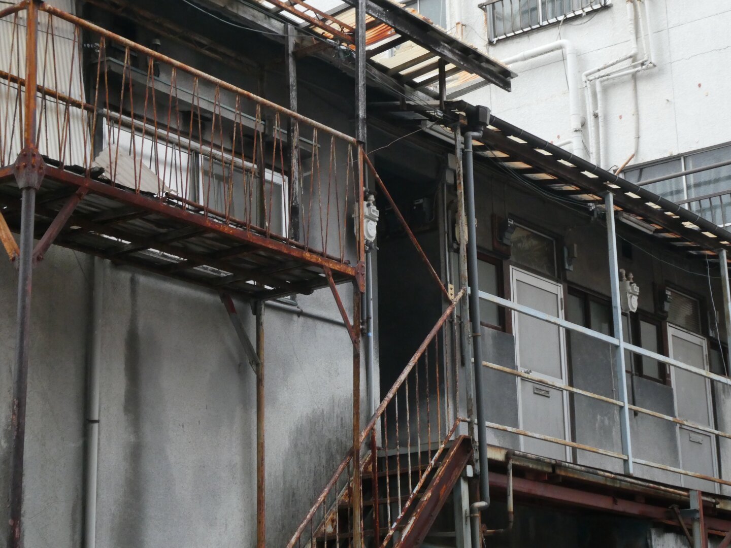 An abandoned entryway with pipes and lines and a gaping mouth of a door