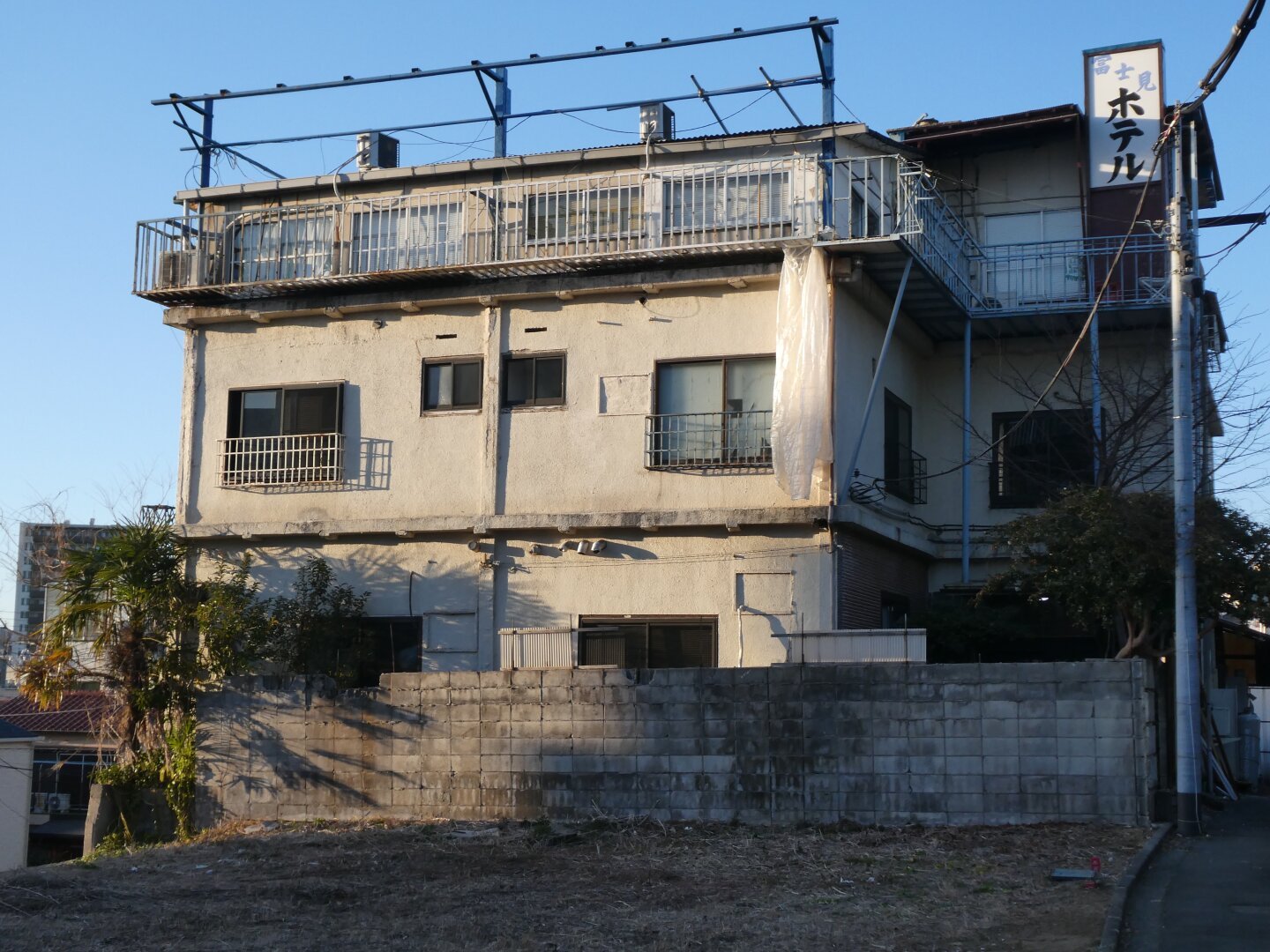 An old apartment stands there, in a barren field. The place seems abandoned but it’s mainly only old and in need of repair