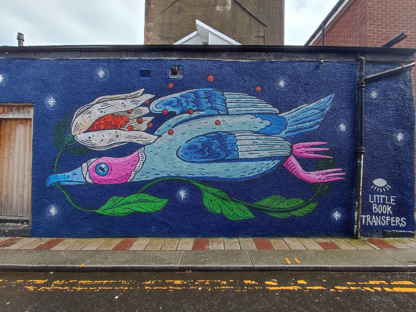 street art on a wall, a blue goose with a flower in its mouth