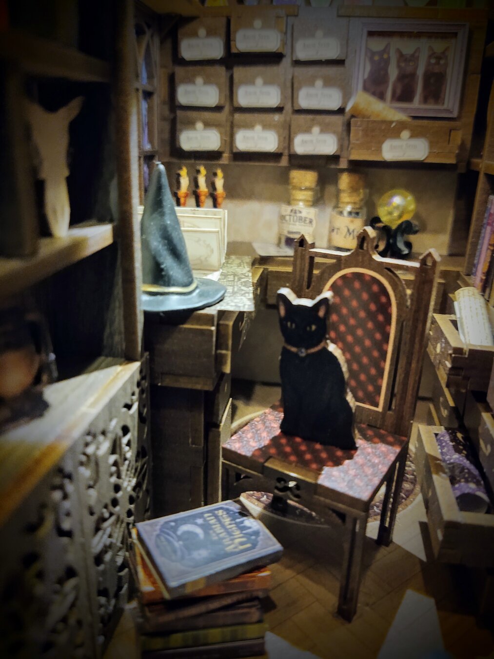 A cardboard black cat sits in a book nook