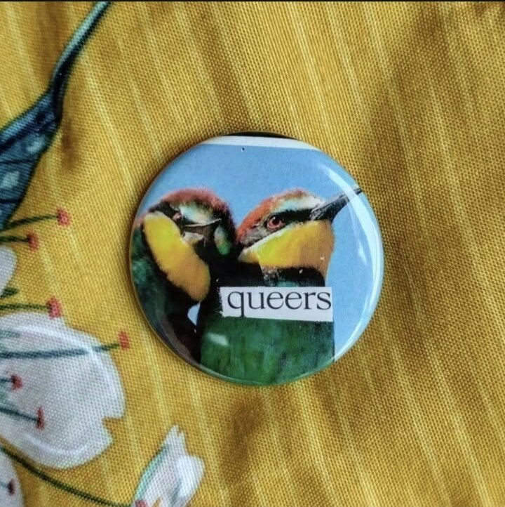 Badge de deux oiseaux très colorés, labellé 