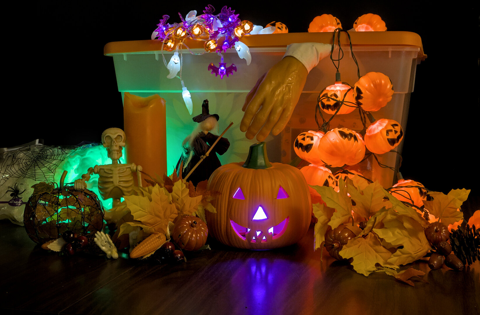 Halloween decorations piled next to a plastic storage container