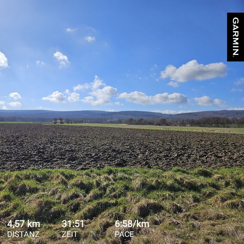 Blauer Himmel mit einzelnen Wolken über dem Deister. Die Sonne scheint. Im Vordergrund ein umgepflügtes Feld. 
Laufdaten: Distanz 4,57km, Zeit 31:51, Pace 6:58