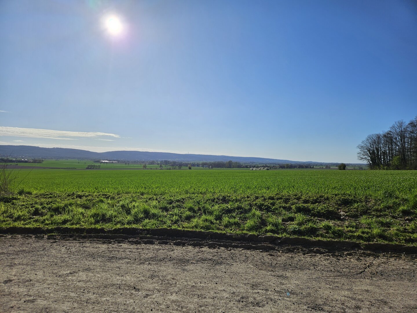 Blick vom Gehrdener Berg auf das Deister Vorland mit Degersen, Egestorf und Barsinghausen. Darüber blauer Himmel und Sonne.