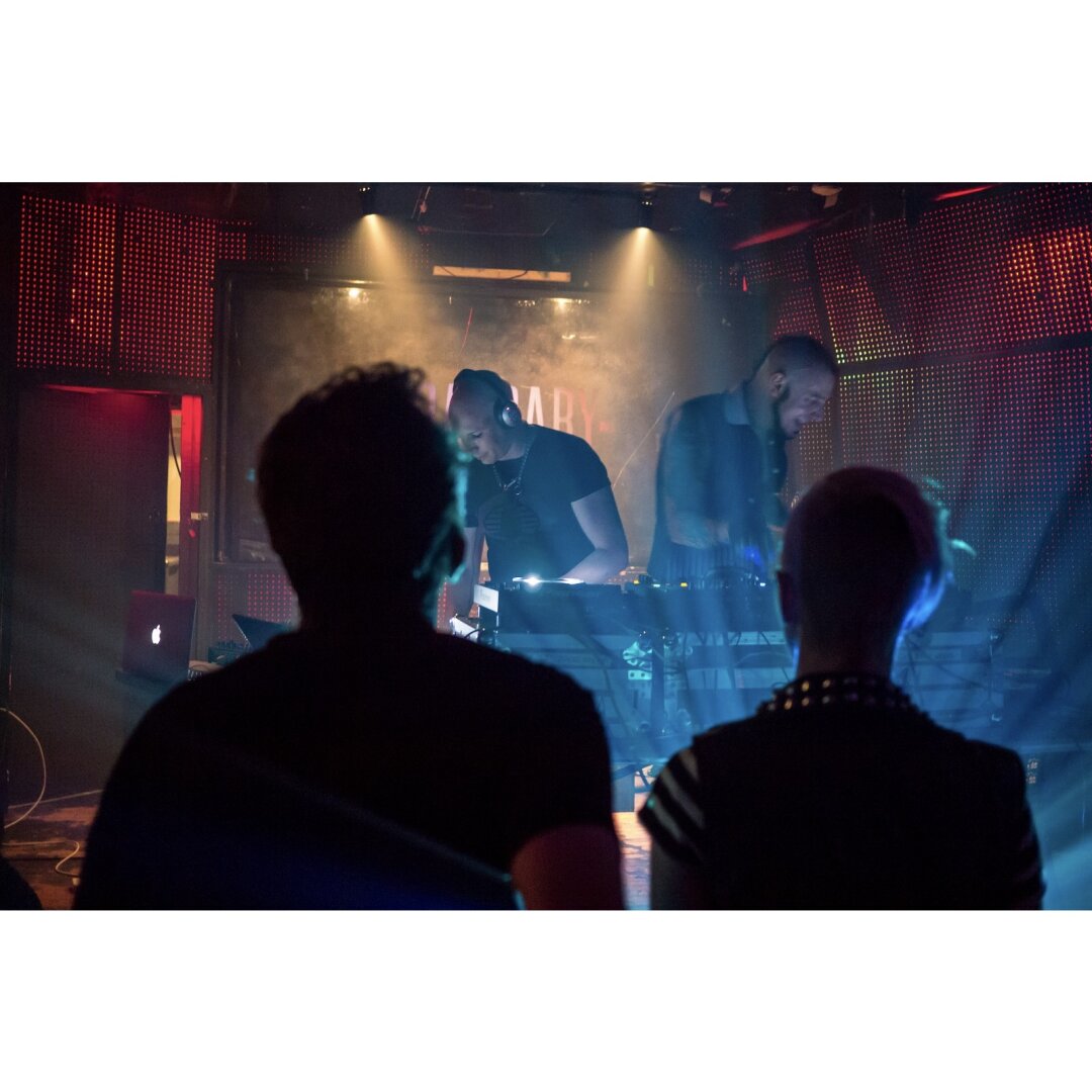 Two DJs framed by two spectators at the Barbary in Philadelphia.