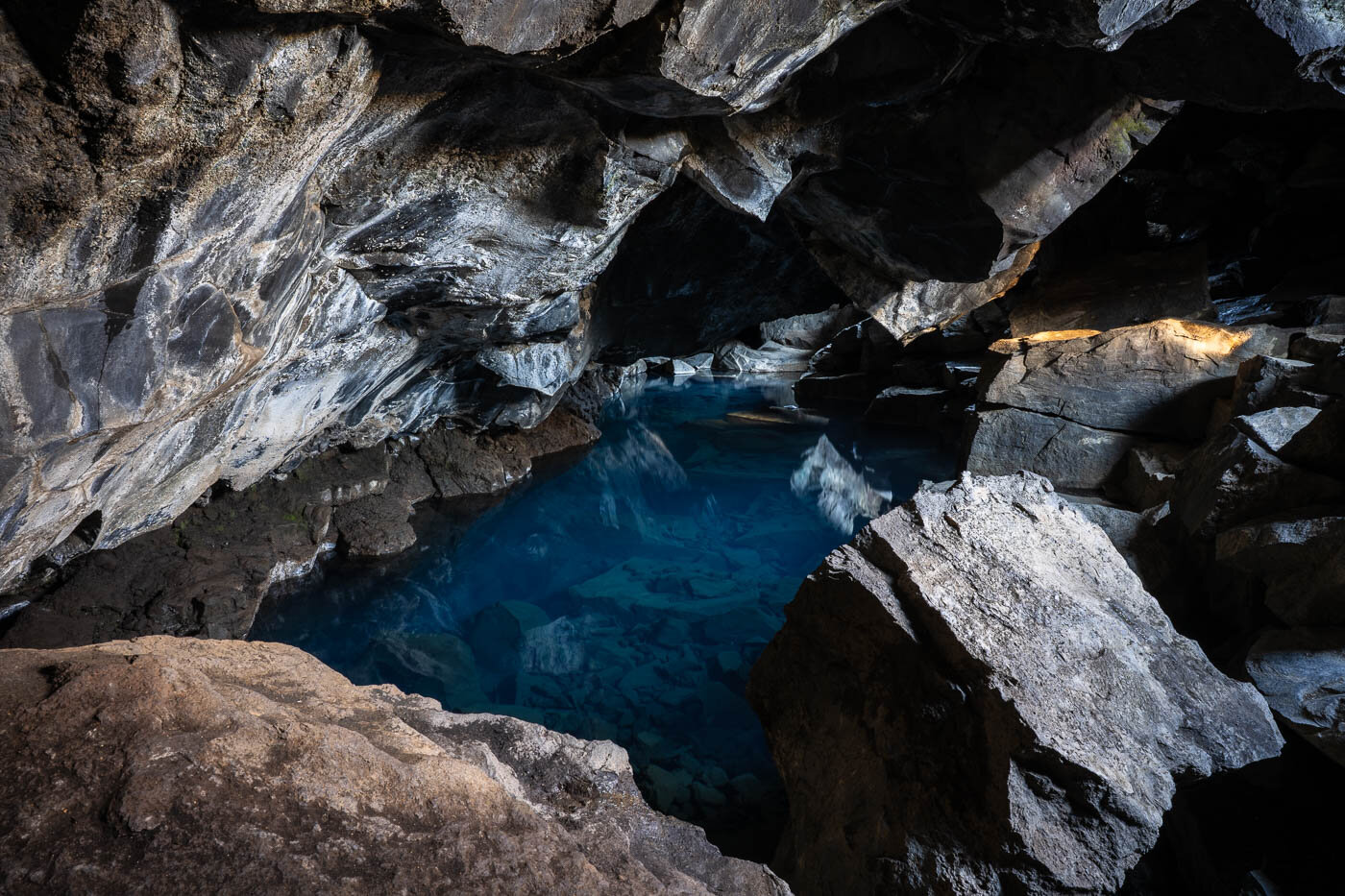Small lava cave Grjótagjá near Lake Mývatn, renowned for its crystal-clear geothermal hot springs that once served as a popular bathing spot.