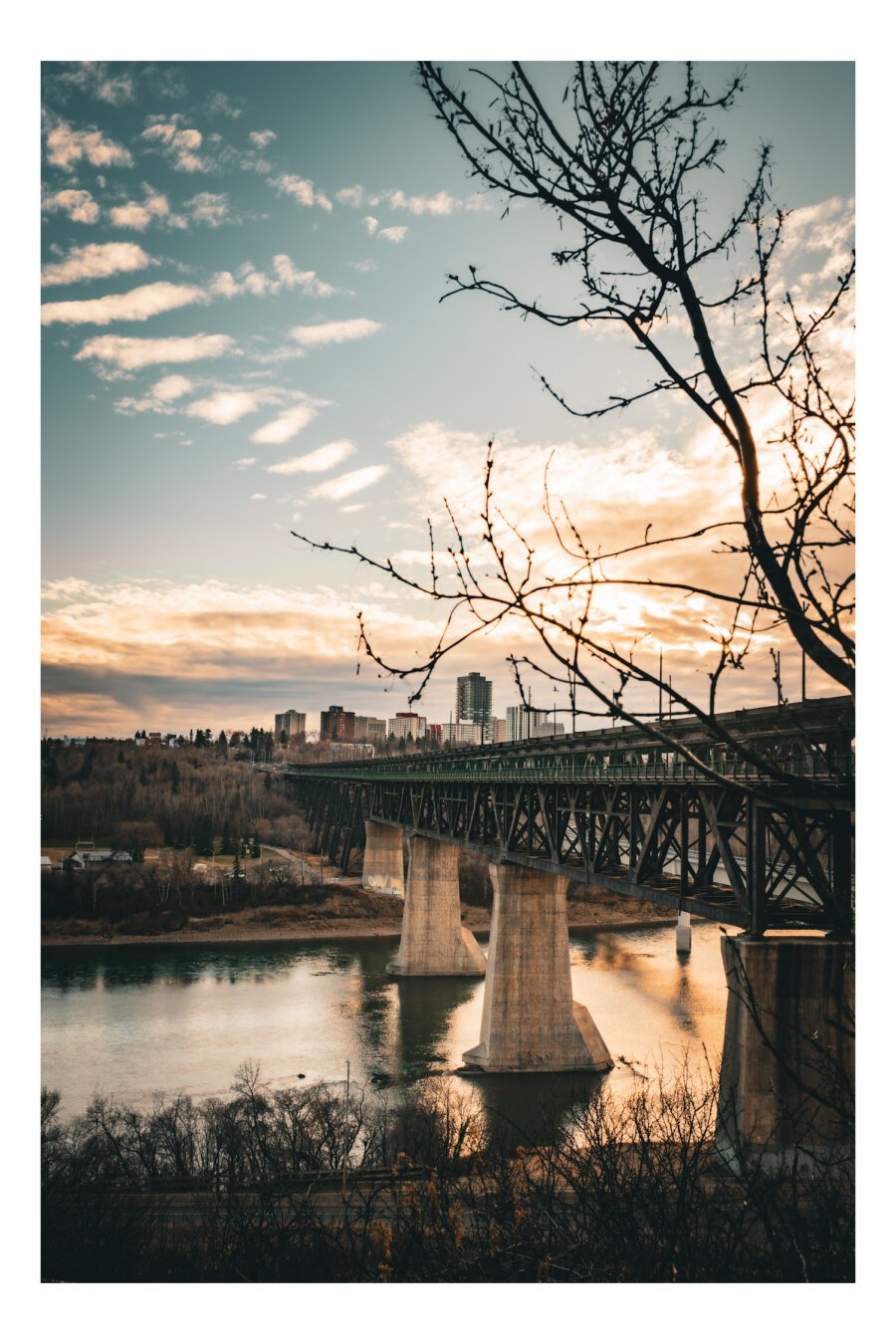 A sunset lights up a large iron bridge that spans the North Saskatchewan in Edmonton.