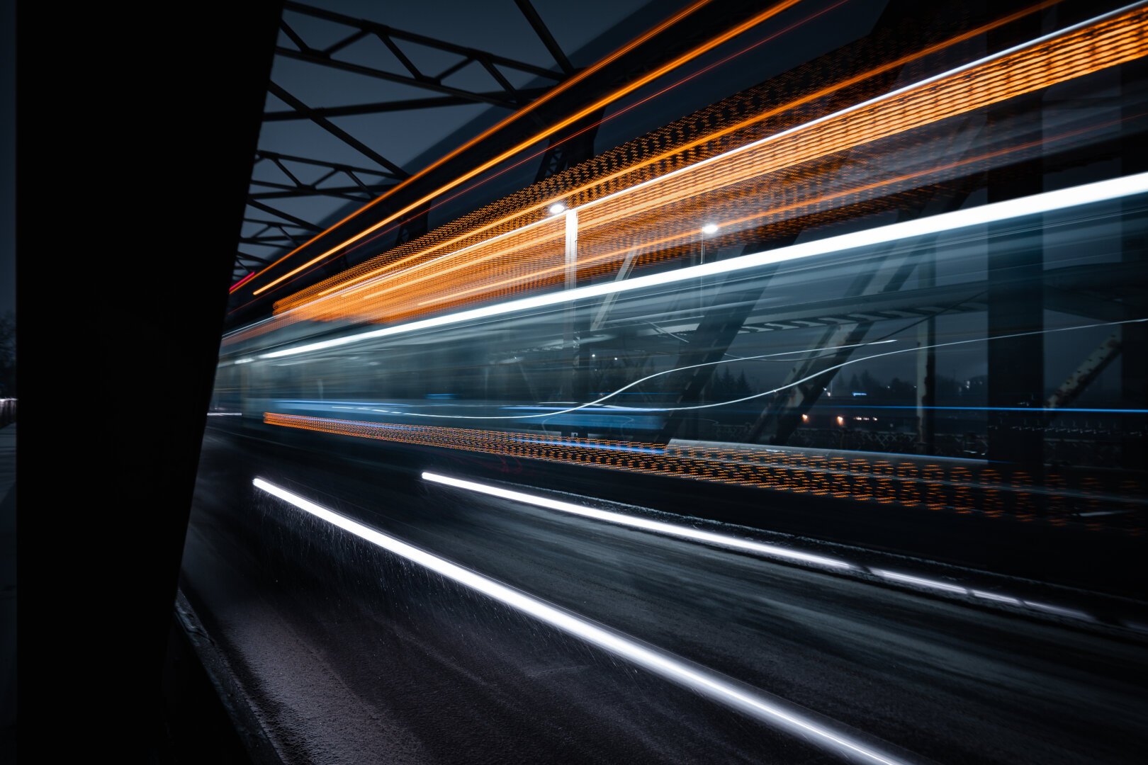 A long exposure of a bus going over a bridge. The lights and digital signage stretch out and repeat across the image, most notably the route number ‘8’ shows up as ‘8888888888’