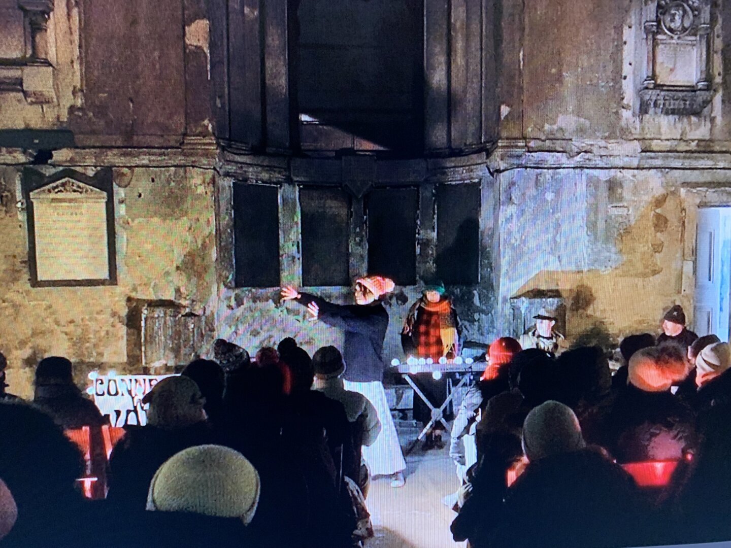 Literally Me telling a scary but cosy story in a derelict chapel in London by candlelight. You can see the live band behind me. Shot was taken off a screen from one of my videos so is a bit grainy and you can see quite a lot of seated adult audience