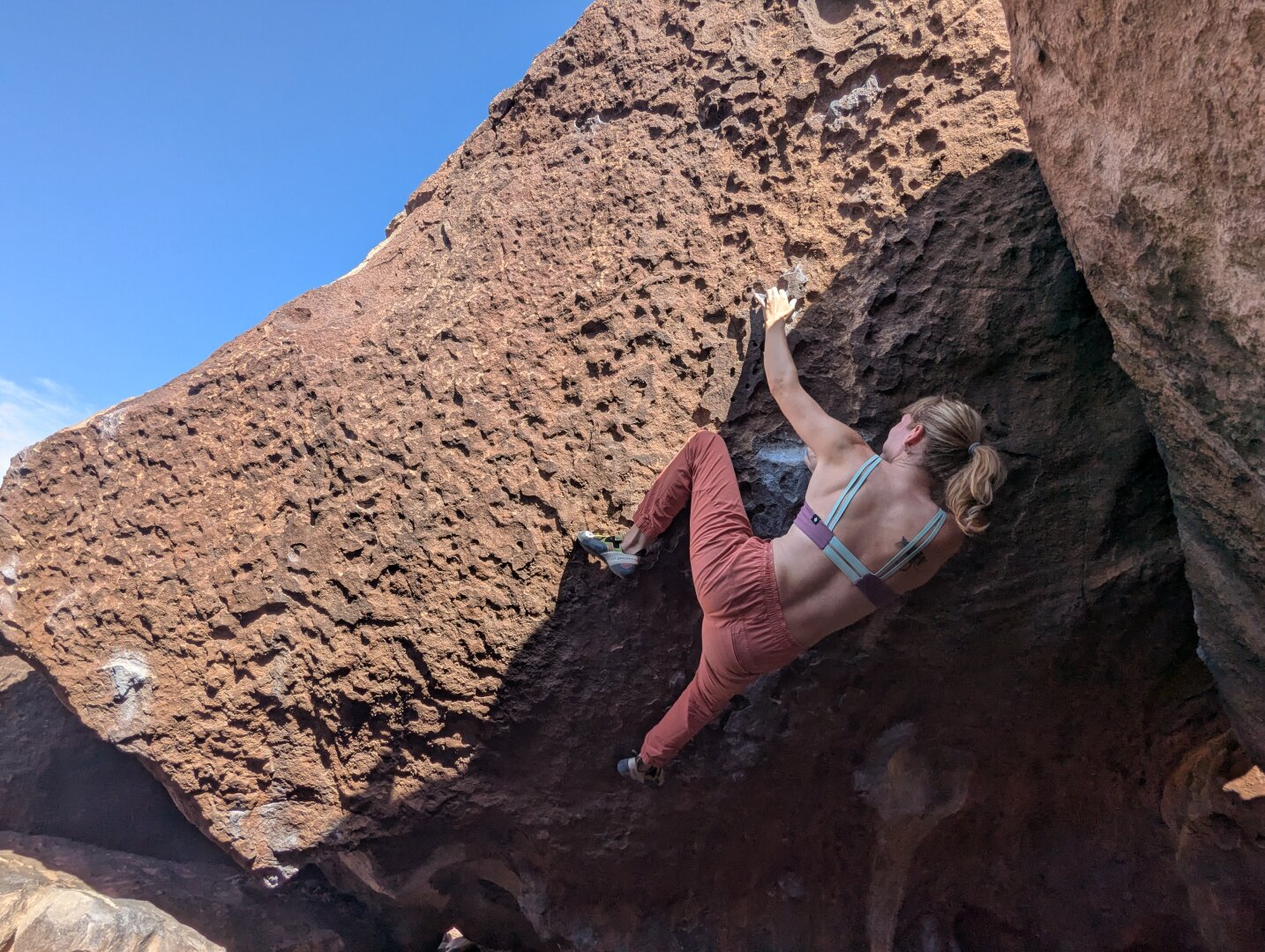 A boulderer on an overhanging rock face