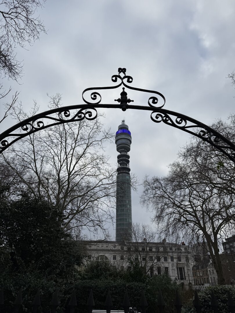 BT Tower seen through an archway of a gate to a private garden in Fitzrovia