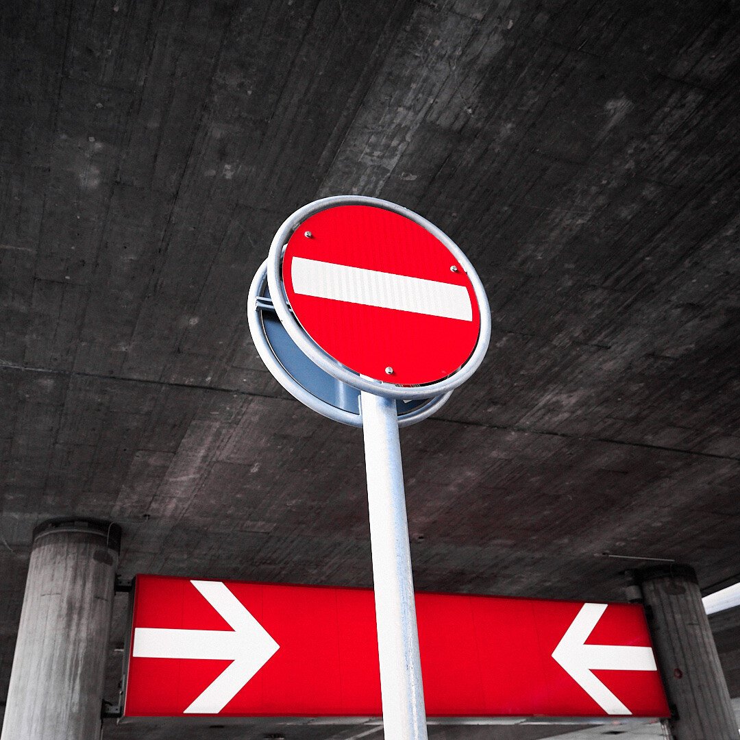 A red no entry sign on an SBB red sign in background, under a concrete flyover