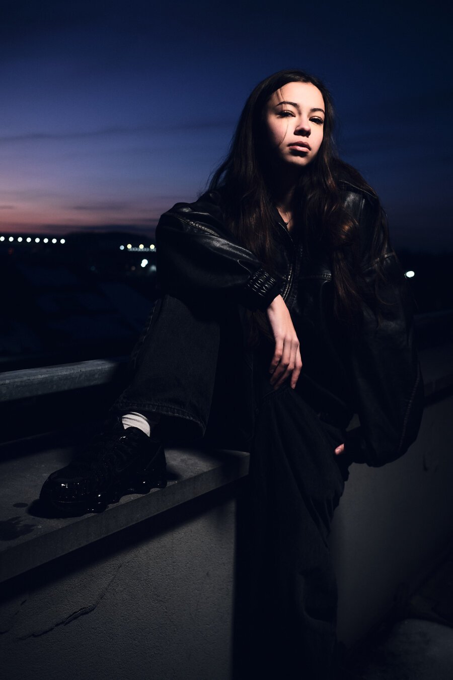 Zia on her balcony in front of a sunset