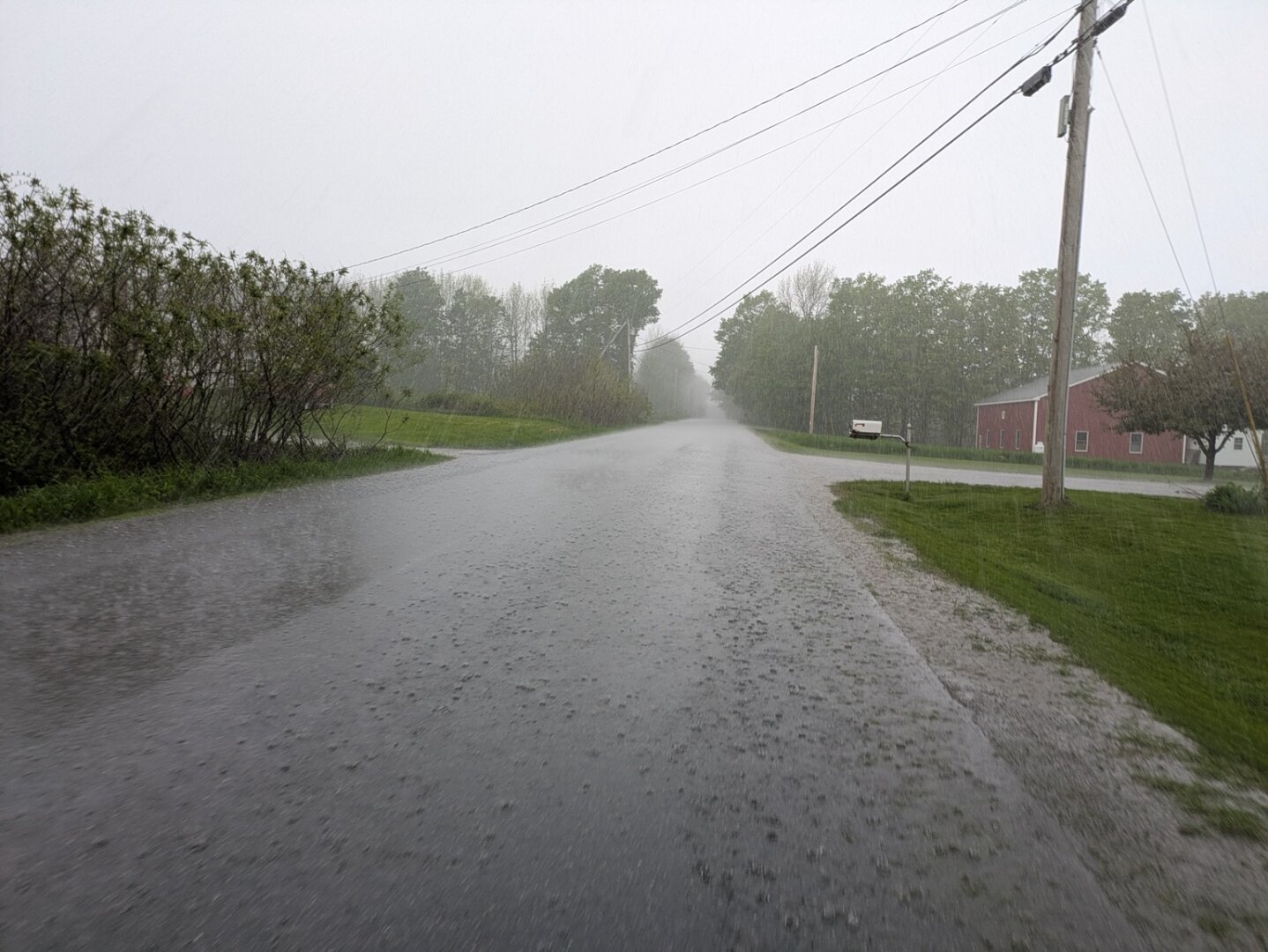 A paved rural road in heavy rain.