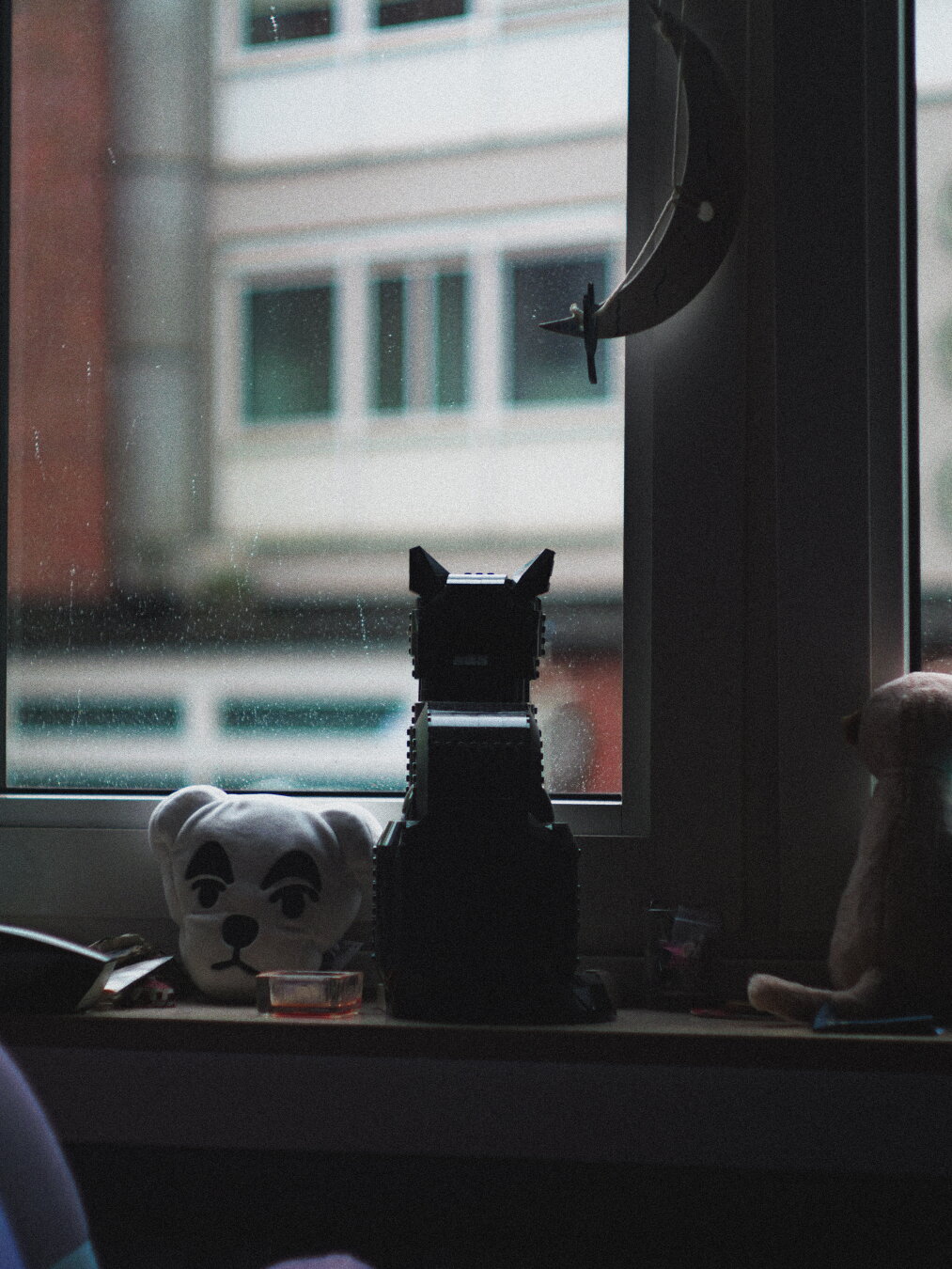 A lego cat watching the rain outside a window and KK Slider from animal crossing watches you looking at this picture.