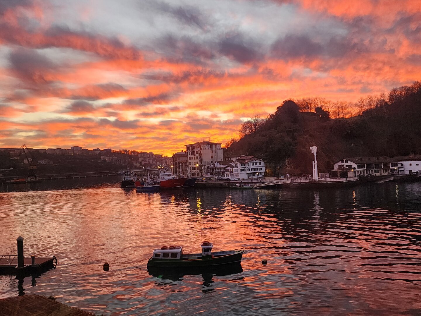 Atardecer  naranja con barco en primer plano desde Donibane