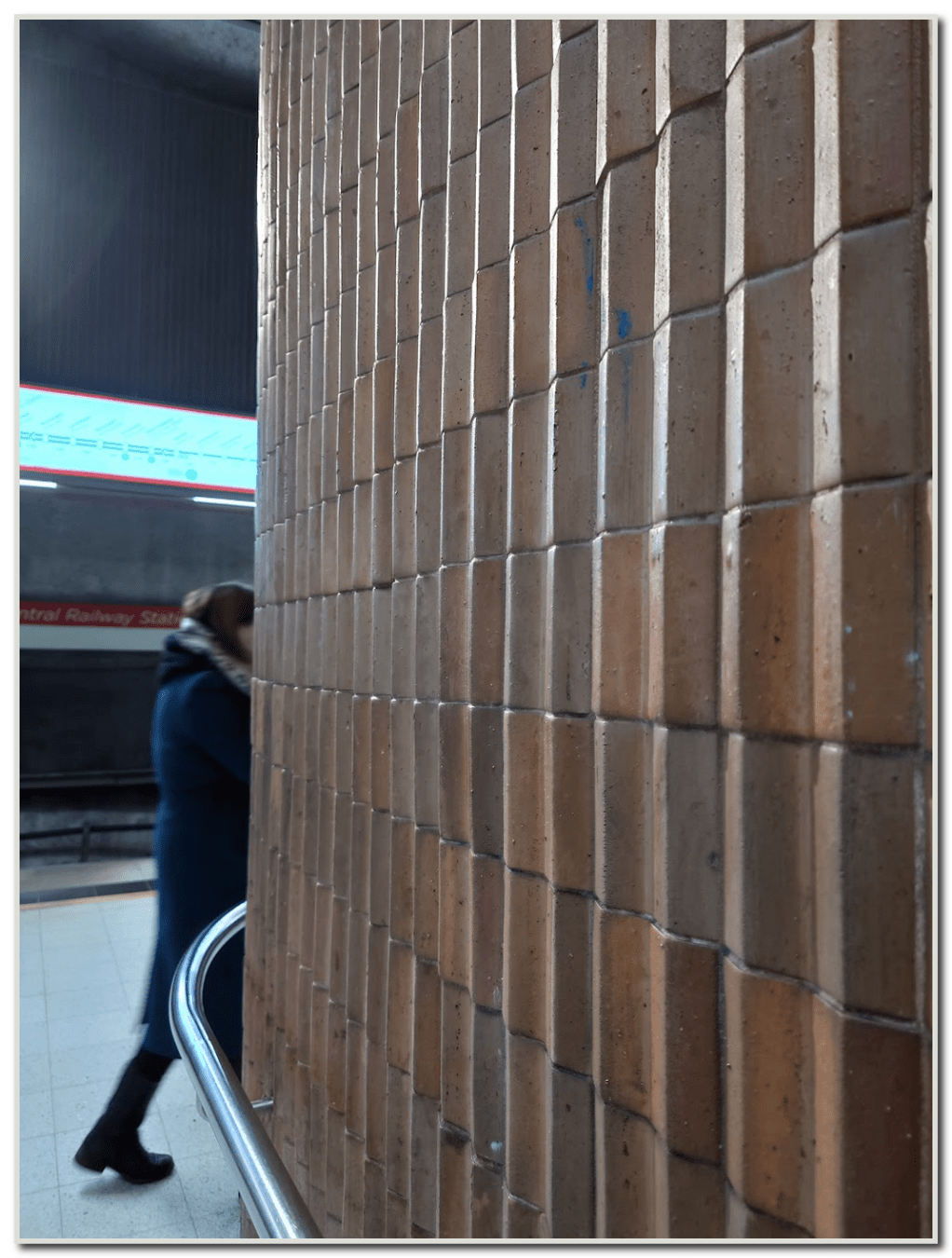 The ceramic wall surface and a passerby at the Metrostation of Rautatientori The ceramic wall surfaces, at Rautatientori Metrostation and also at Kamppi are situated on the station platforms, and were designed by Terhi Juurinen and Riitta Pensanen (Seenat Oy)