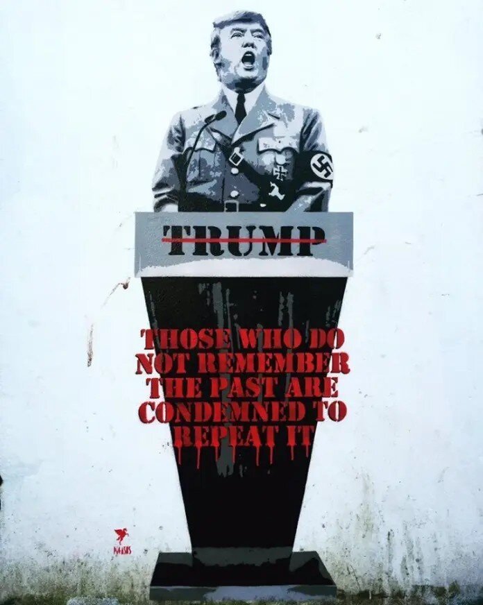 treet art mural by Pegasus in Bristol, UK, depicting Donald Trump in a Nazi uniform, standing at a podium with his name “TRUMP” partially crossed out in red. The podium bears the ominous quote, “THOSE WHO DO NOT REMEMBER THE PAST ARE CONDEMNED TO REPEAT IT,” dripping in blood-red paint. The artwork draws a direct comparison between Trump and historical fascist leaders, serving as a stark political statement. The stencil-style piece is set against a white wall with visible dirt and weathering, emphasizing its raw and urgent message.