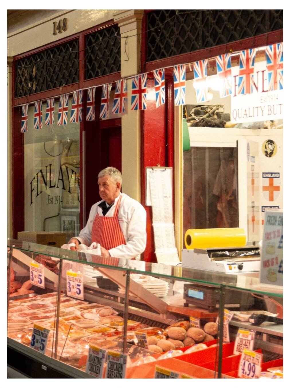 Butcher standing behind his display