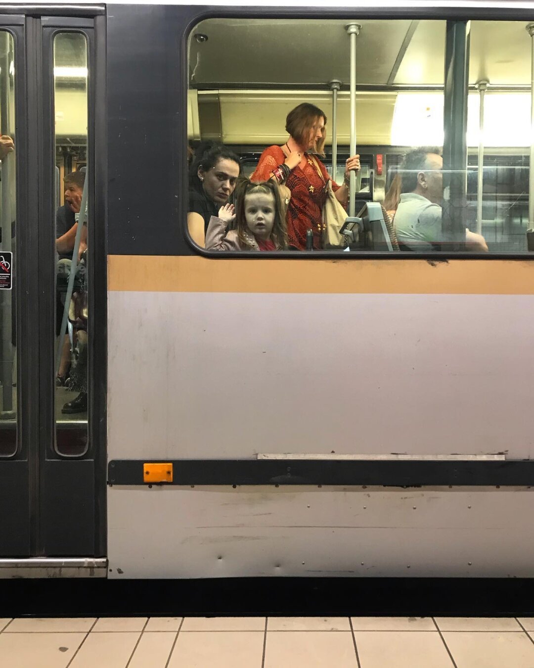 Tram, enfants et adultes à la fenêtre.