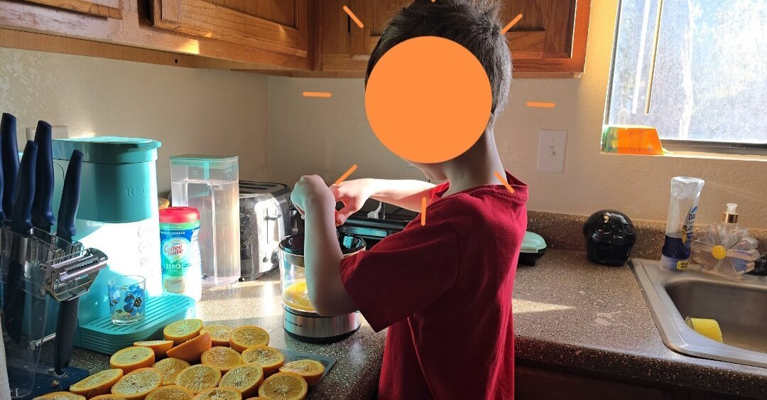 Little boy making oranges juice